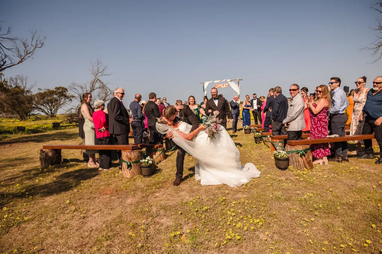 Jason dips Courtney for a kiss at the end of the aisle as guests cheer
