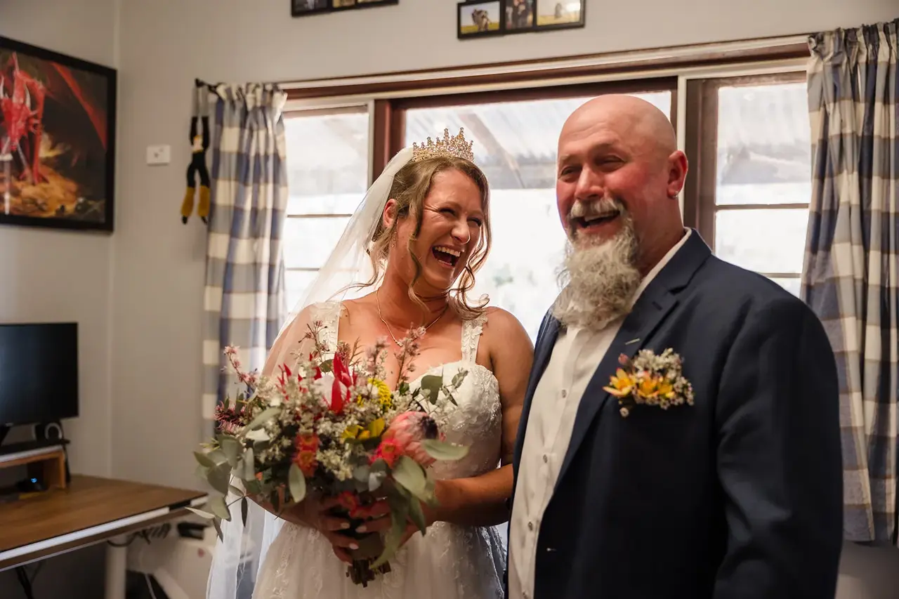 Courtney and her dad laughing together, bouquet in hand