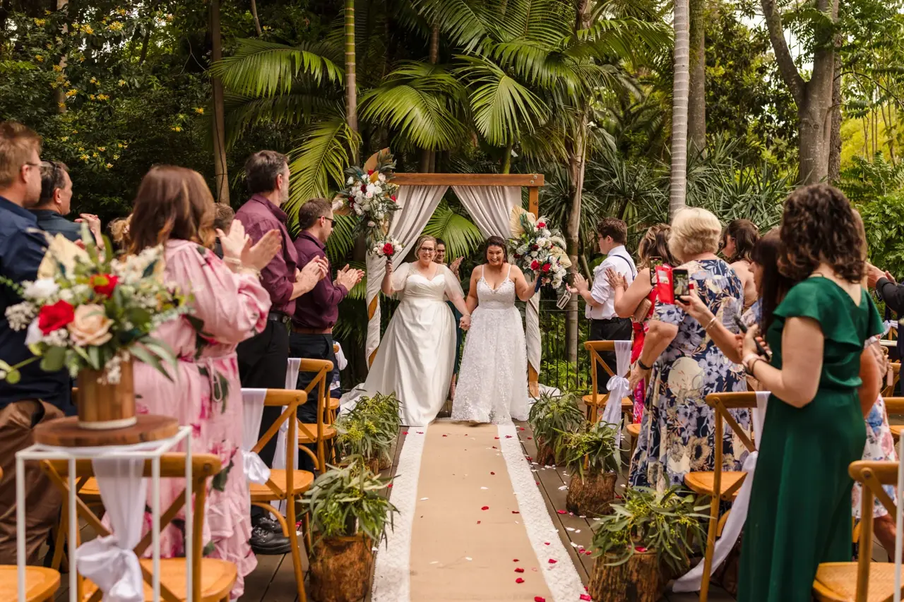 Just married, Kat and Jess walk back up the aisle together to applause at their Wanneroo Botanic Gardens wedding