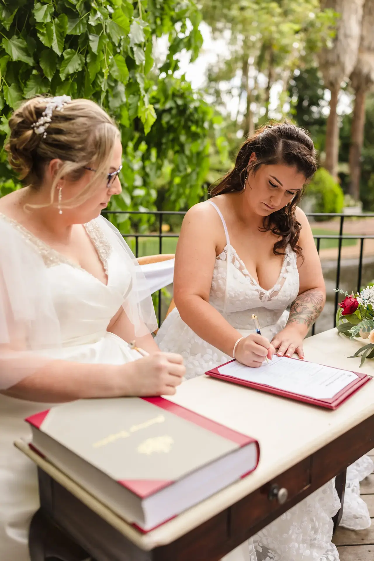Kat and Jess signing the register in the gardens