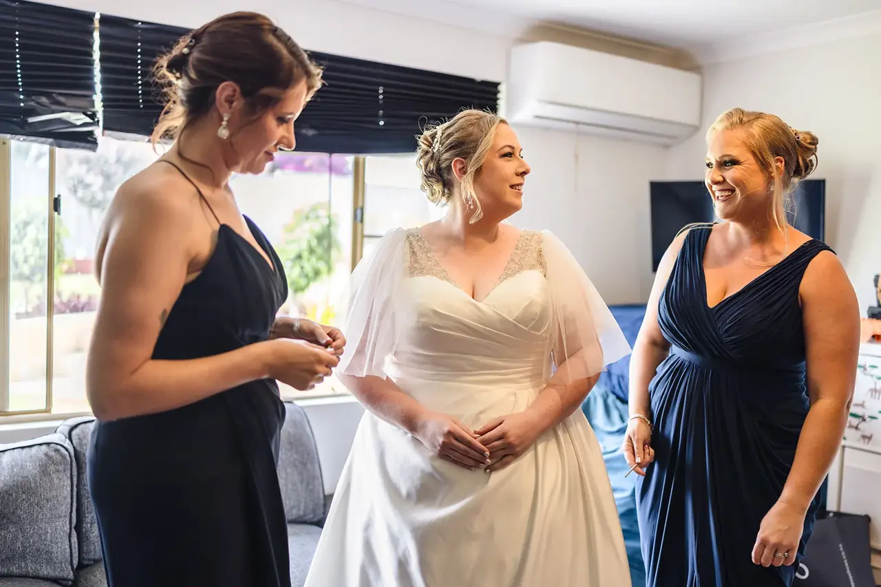 Jess getting ready in her wedding dress with her bridesmaids at home in Clarkson