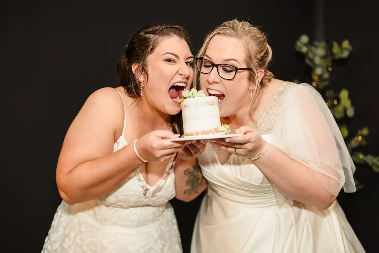 Kat and Jess sharing a bite of their wedding cake