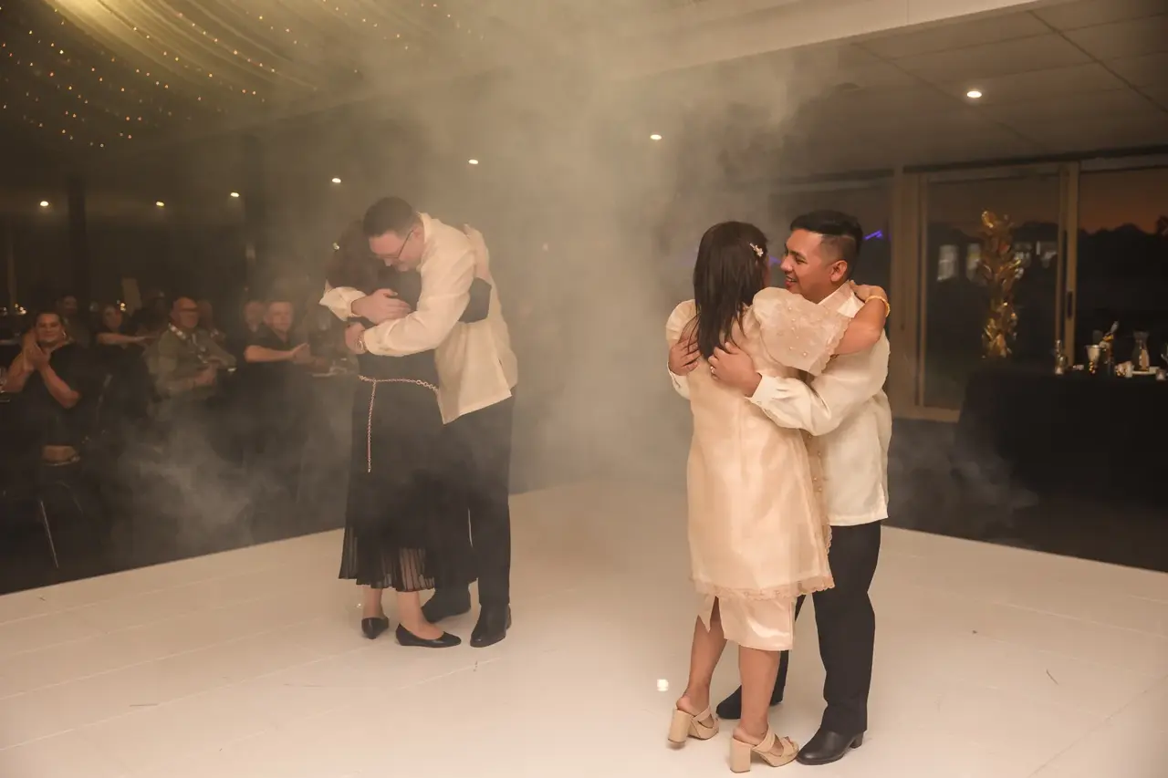 Lloyd and Mitch dancing with their mothers in the low fog at their Burswood on Swan reception