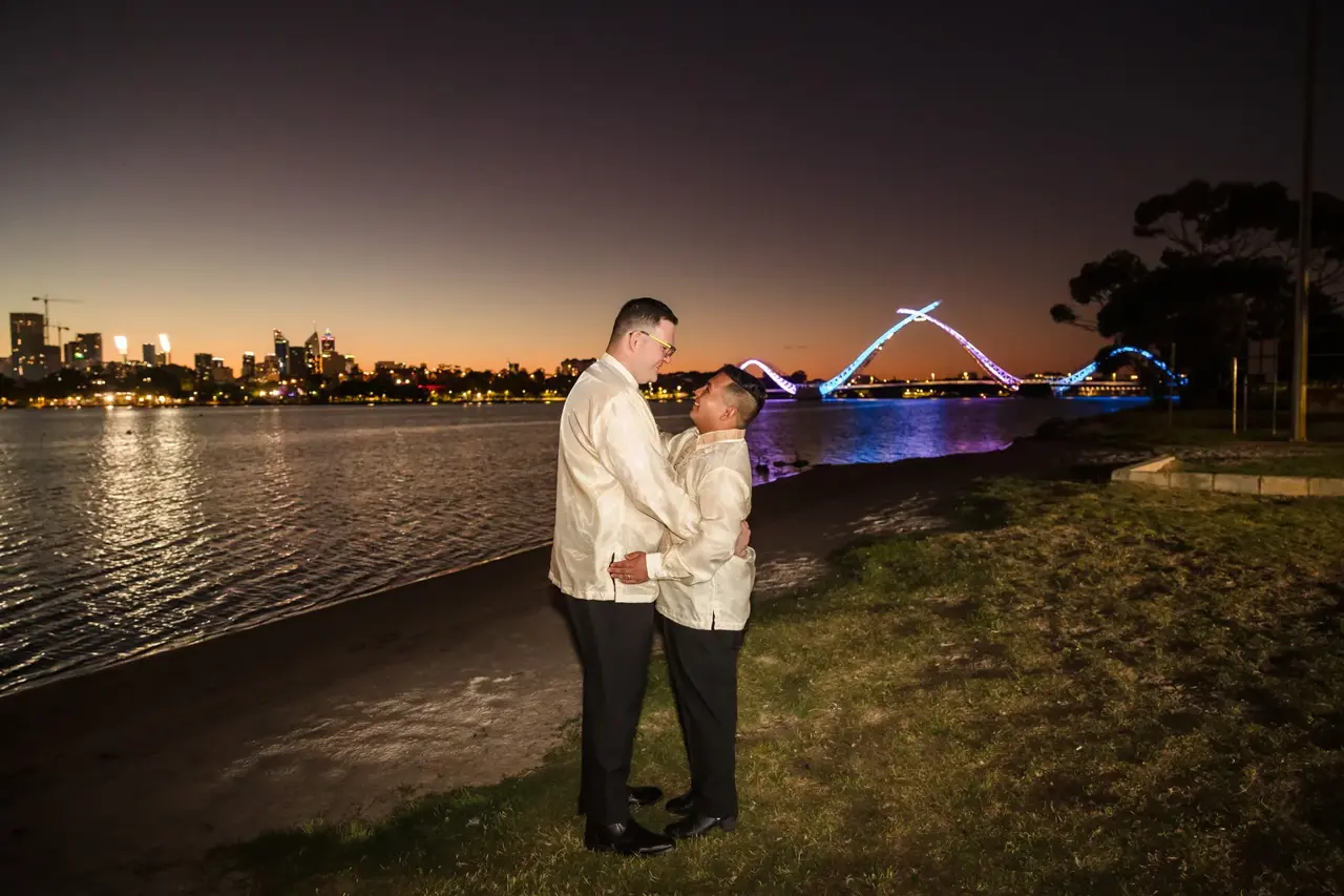 Lloyd and Mitch by the Swan River at night with the lit Matagarup bridge behind at Burswood on Swan