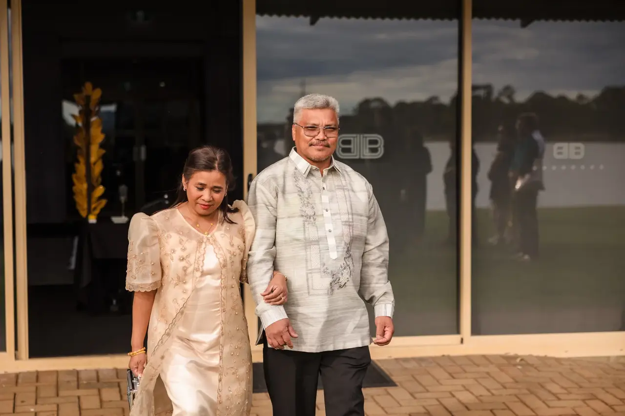 A parent walks down the aisle at the riverside ceremony at Burswood on Swan