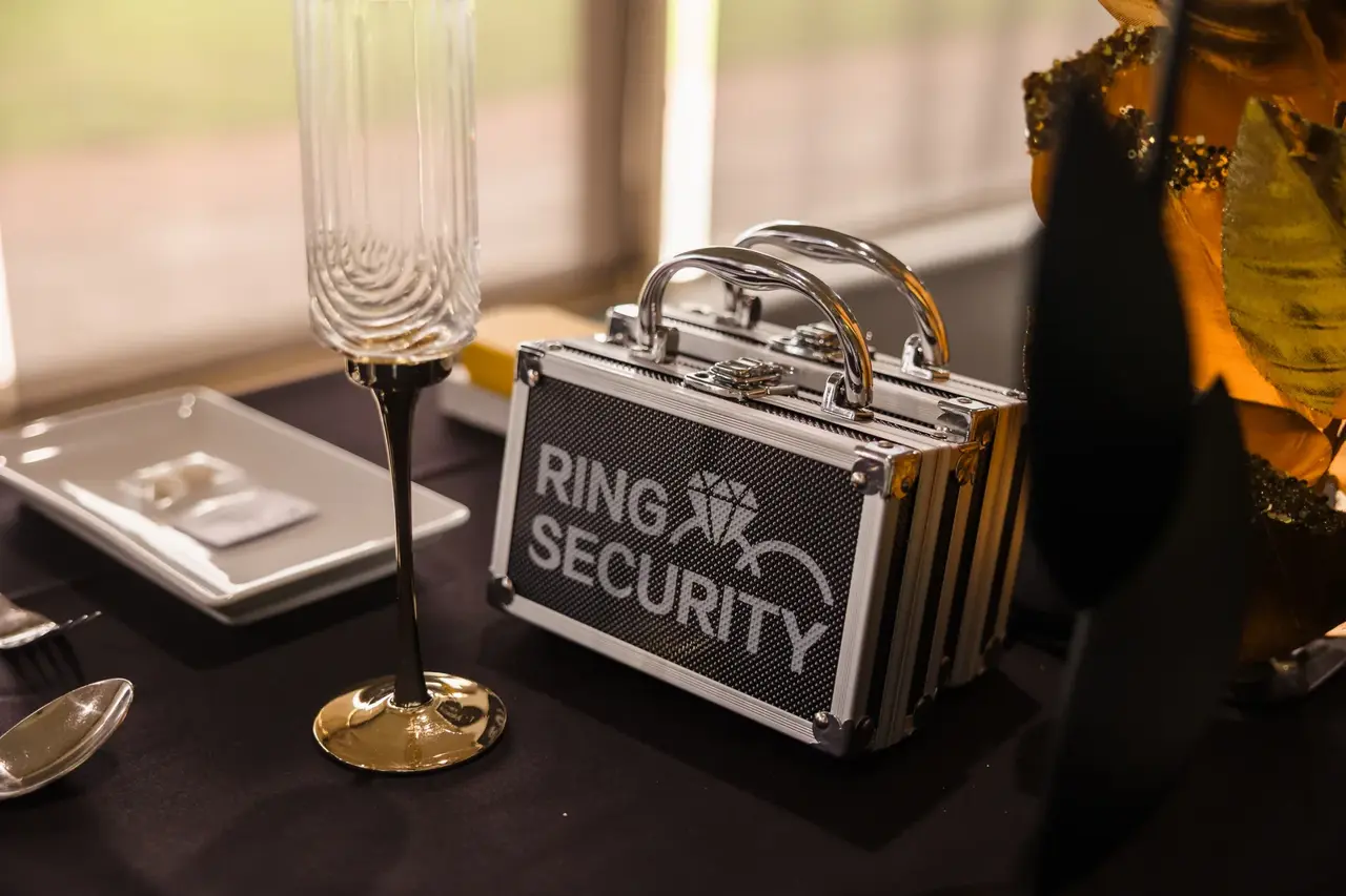 A playful RING SECURITY case among the black and gold table details at Burswood on Swan