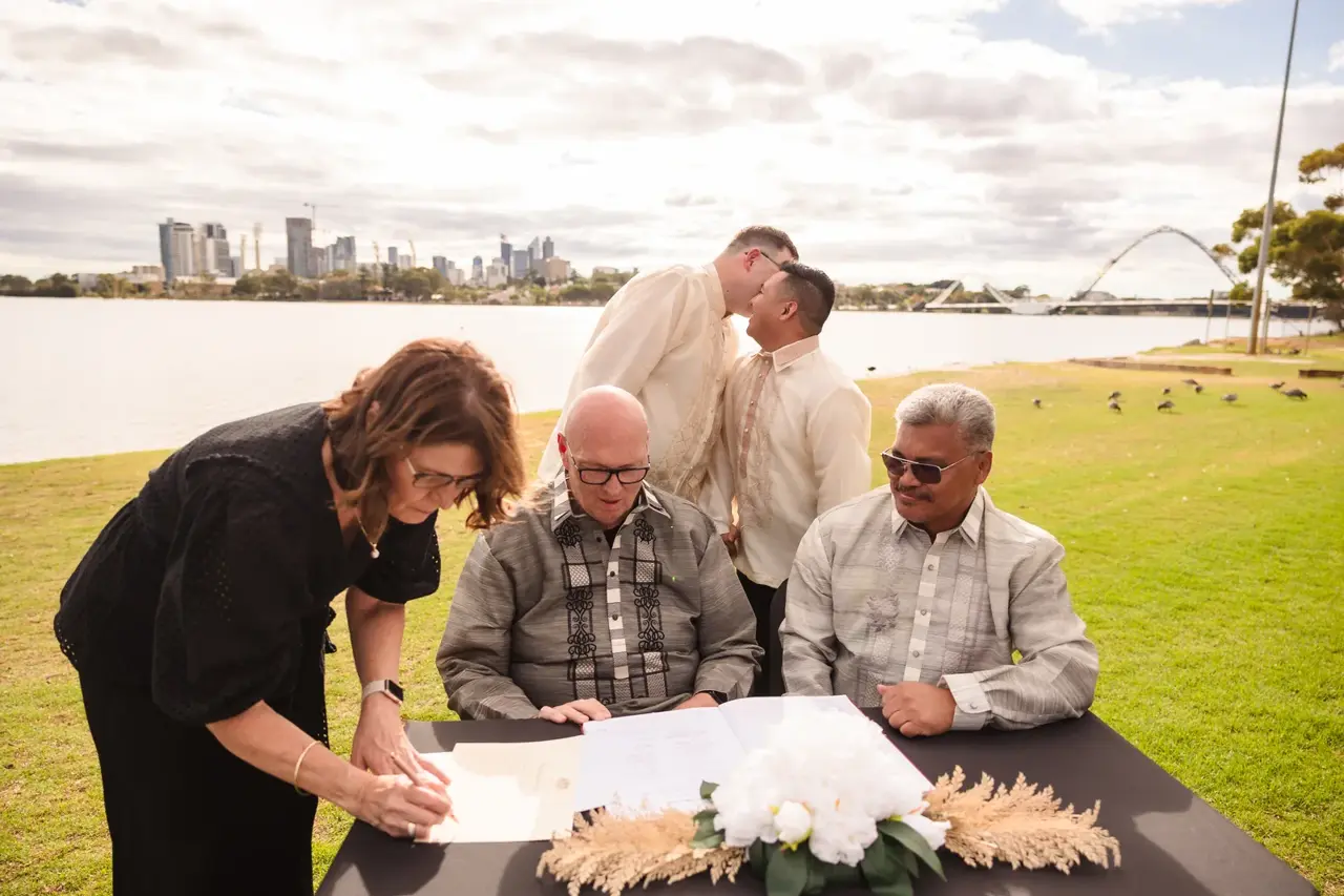 Lloyd and Mitch signing the marriage certificate with their parents at Burswood on Swan