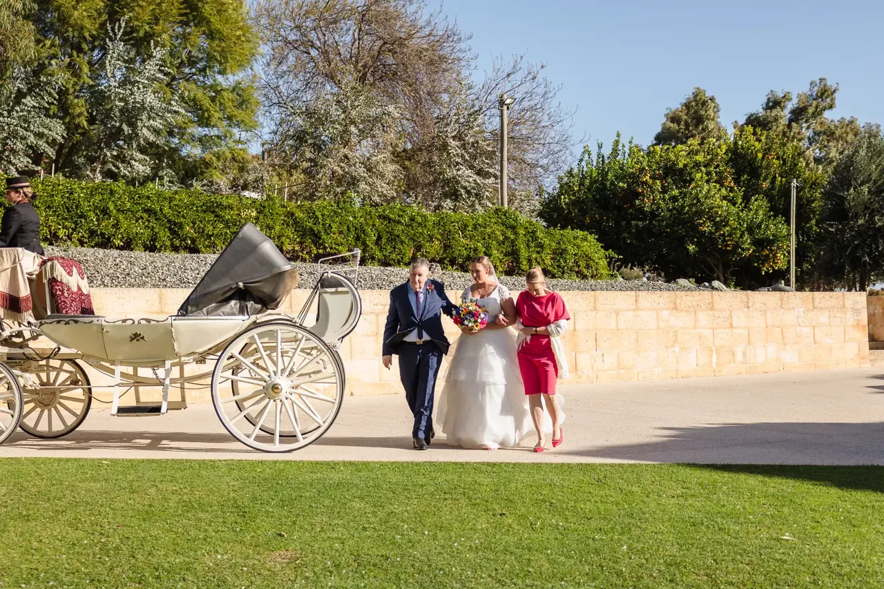 Sarah walks with her parents past the horse-drawn carriage on her way to the ceremony at Quarry Farm