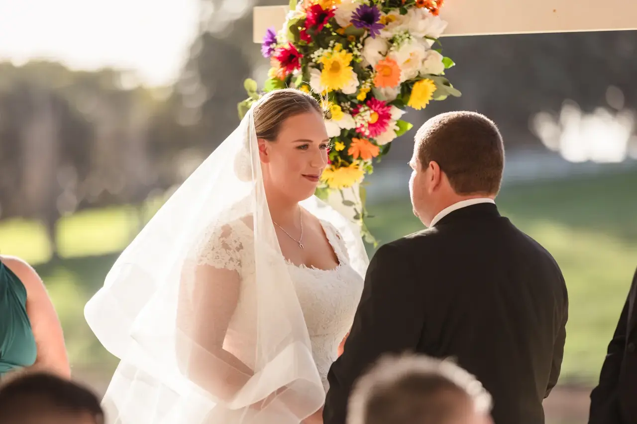 Sarah and James face each other during their vows at the Quarry Farm gazebo