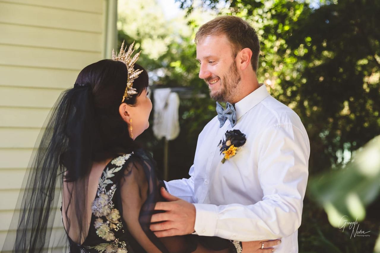 Bride and groom share a joyful First Look moment, smiling at each other in an outdoor garden setting.