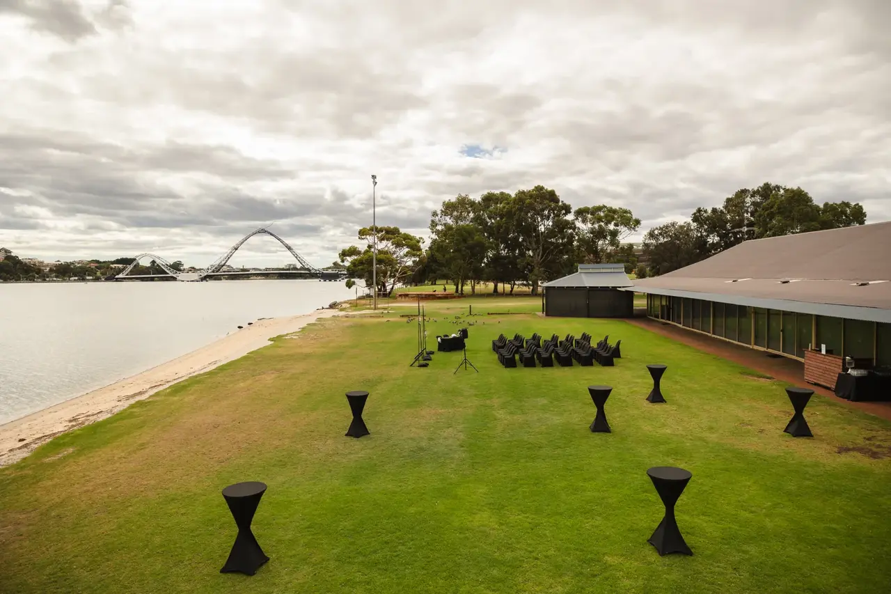 The riverside ceremony lawn and venue building with the Matagarup bridge across the Swan River at Burswood on Swan