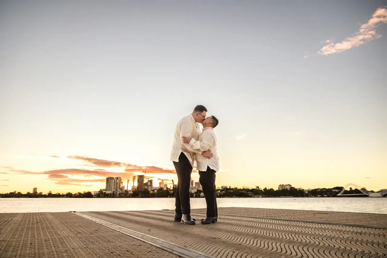 A couple share a dramatic moment on the jetty at sunset over the Swan River at Burswood on Swan