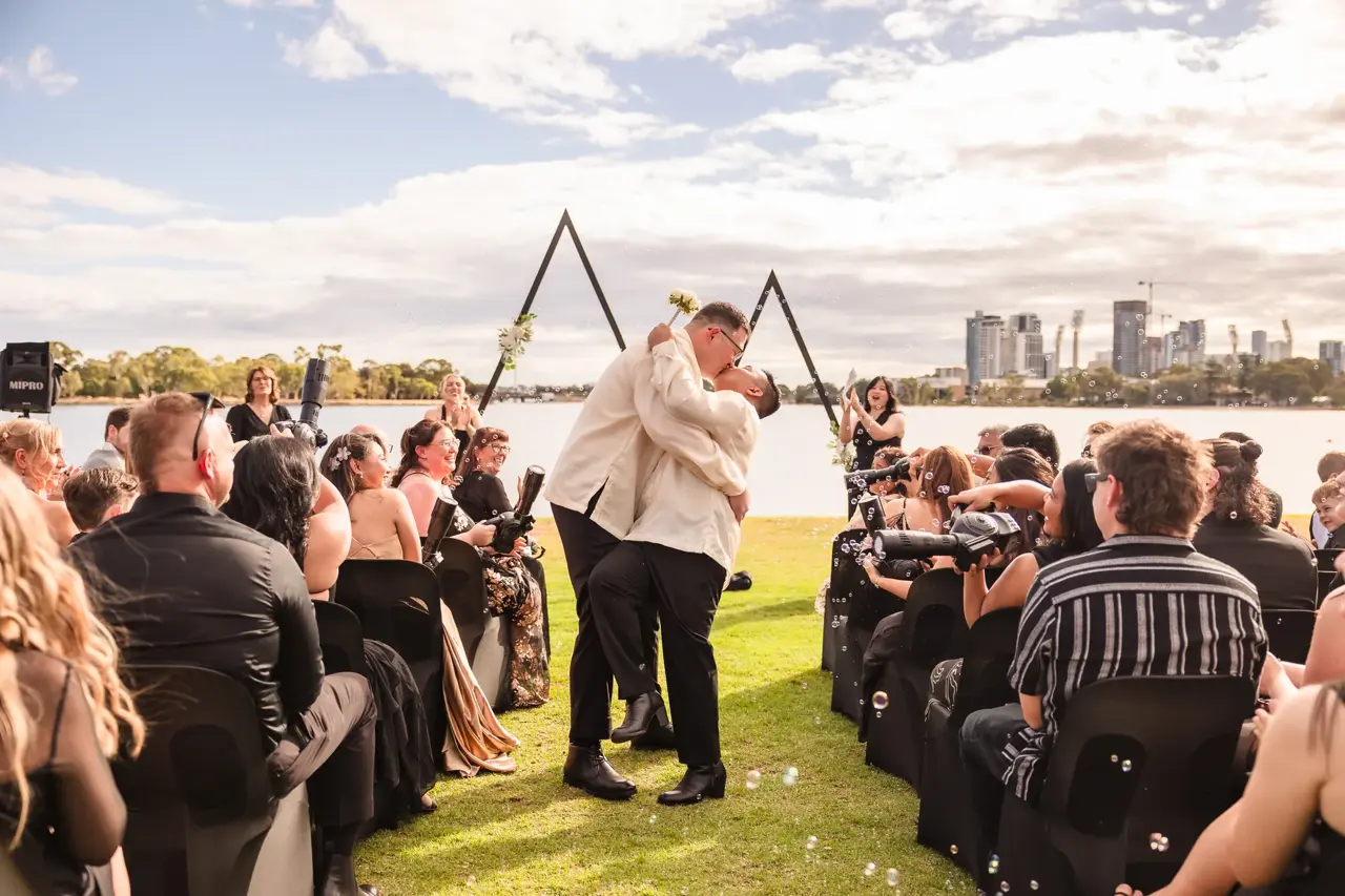 A riverside wedding ceremony on the Swan River with the Perth skyline behind at Burswood on Swan