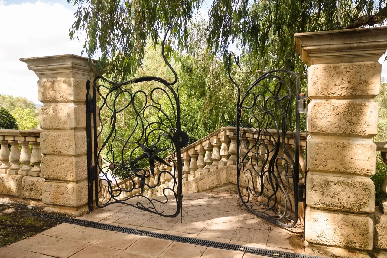 The wrought-iron garden gate between sandstone pillars at Caversham House