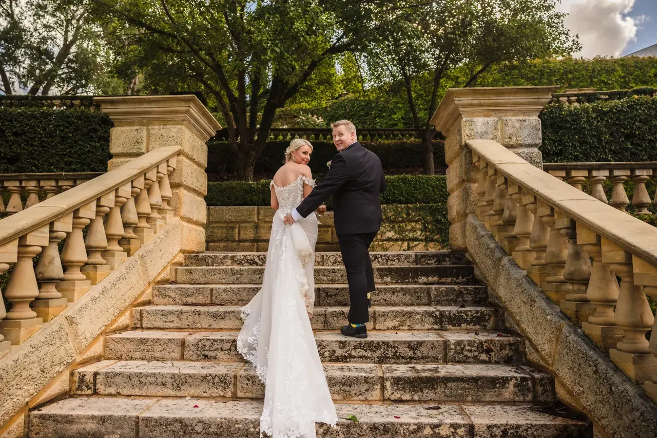 Rosie and Adam climb the grand sandstone staircase at Caversham House between stone balustrades