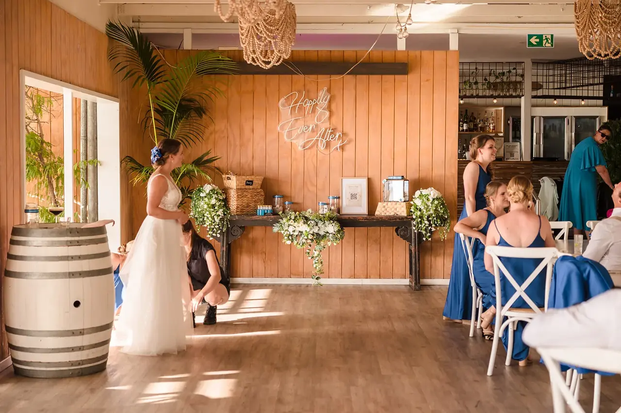 The Boathouse reception room at COAST Port Beach with timber floors and festoon lights