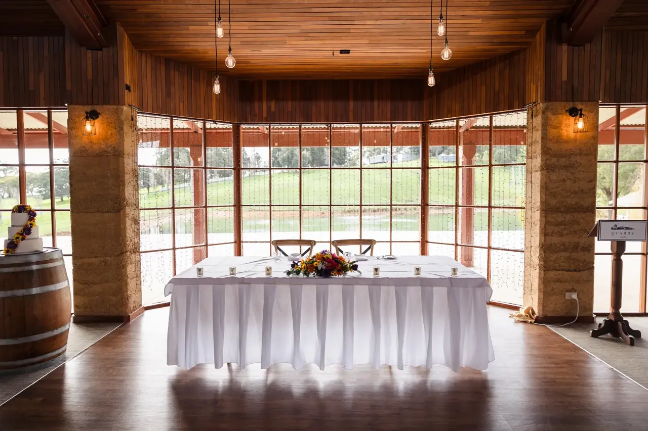The rammed-earth Homestead reception room at Quarry Farm with fairy lights and views over the farm