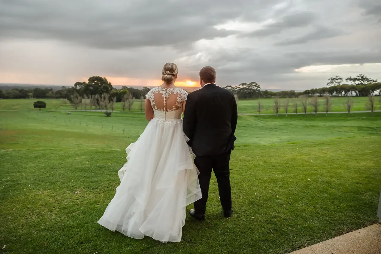 A couple walk across the paddock at sunset at Quarry Farm