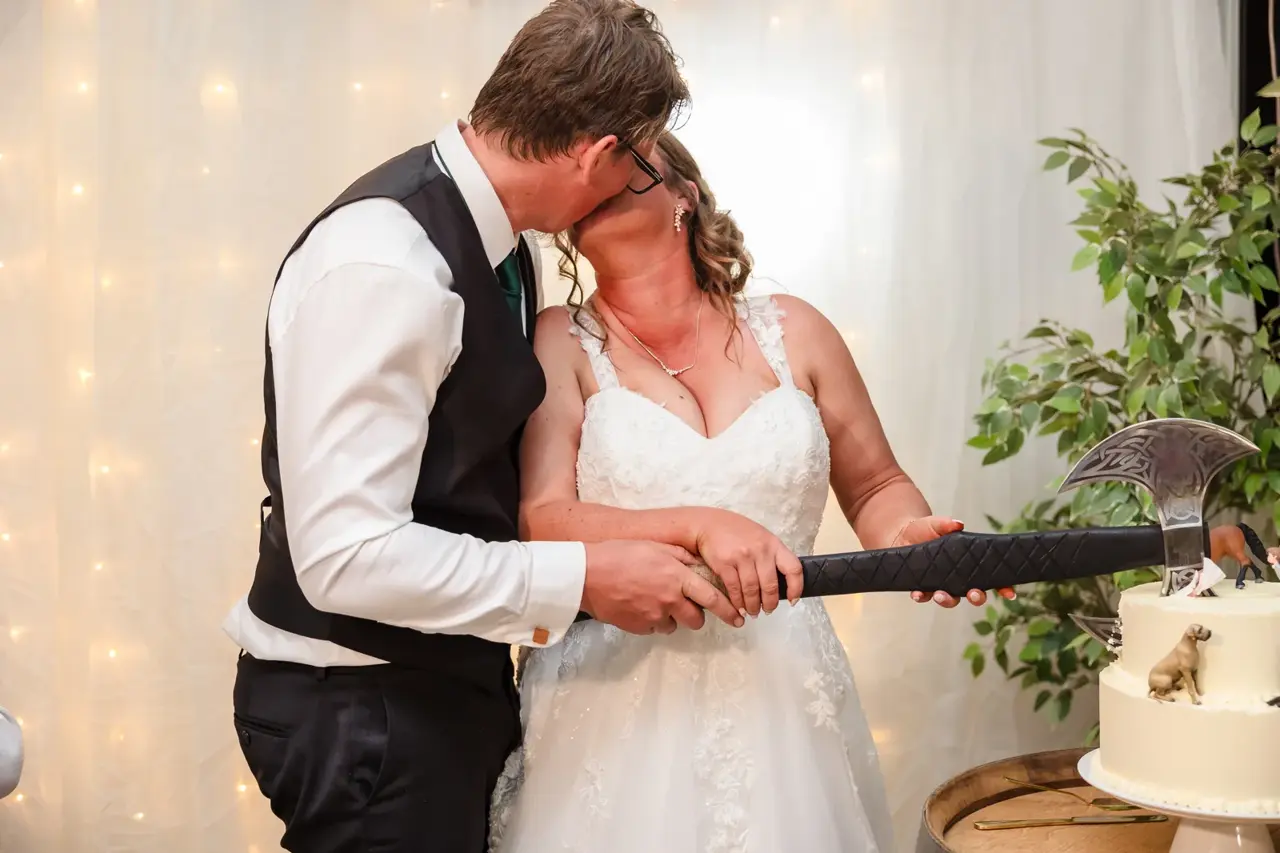 A couple cut their wedding cake with a battle axe at Walkers Hill Vineyard