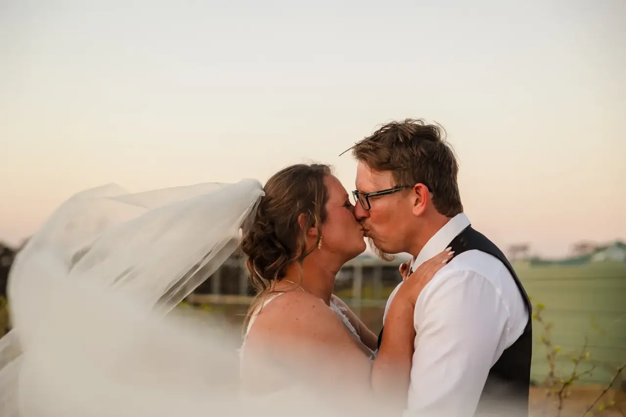 A kiss at sunset with the vineyard behind