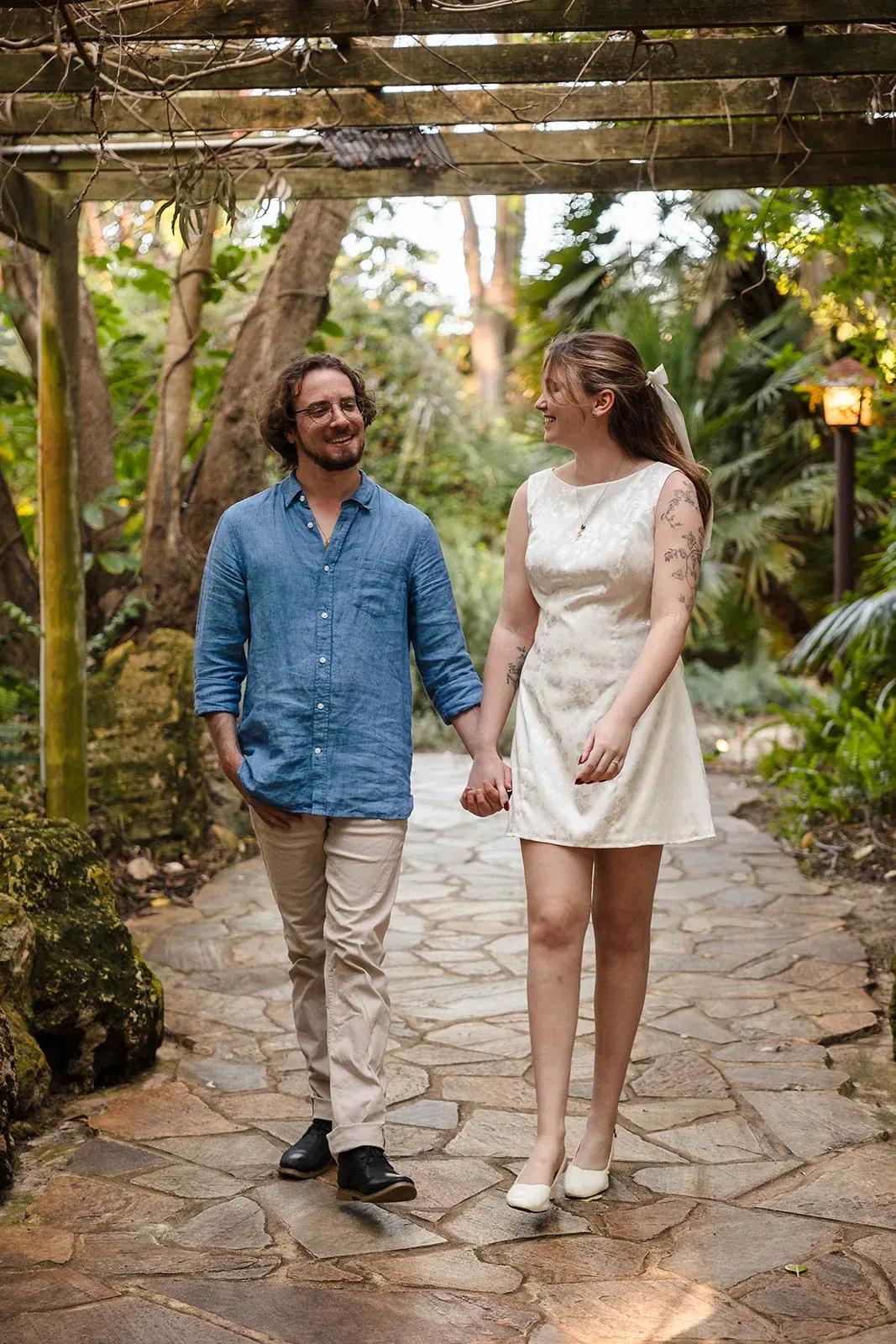 Couple walking the leafy pergola walkway at Wanneroo Botanic Gardens