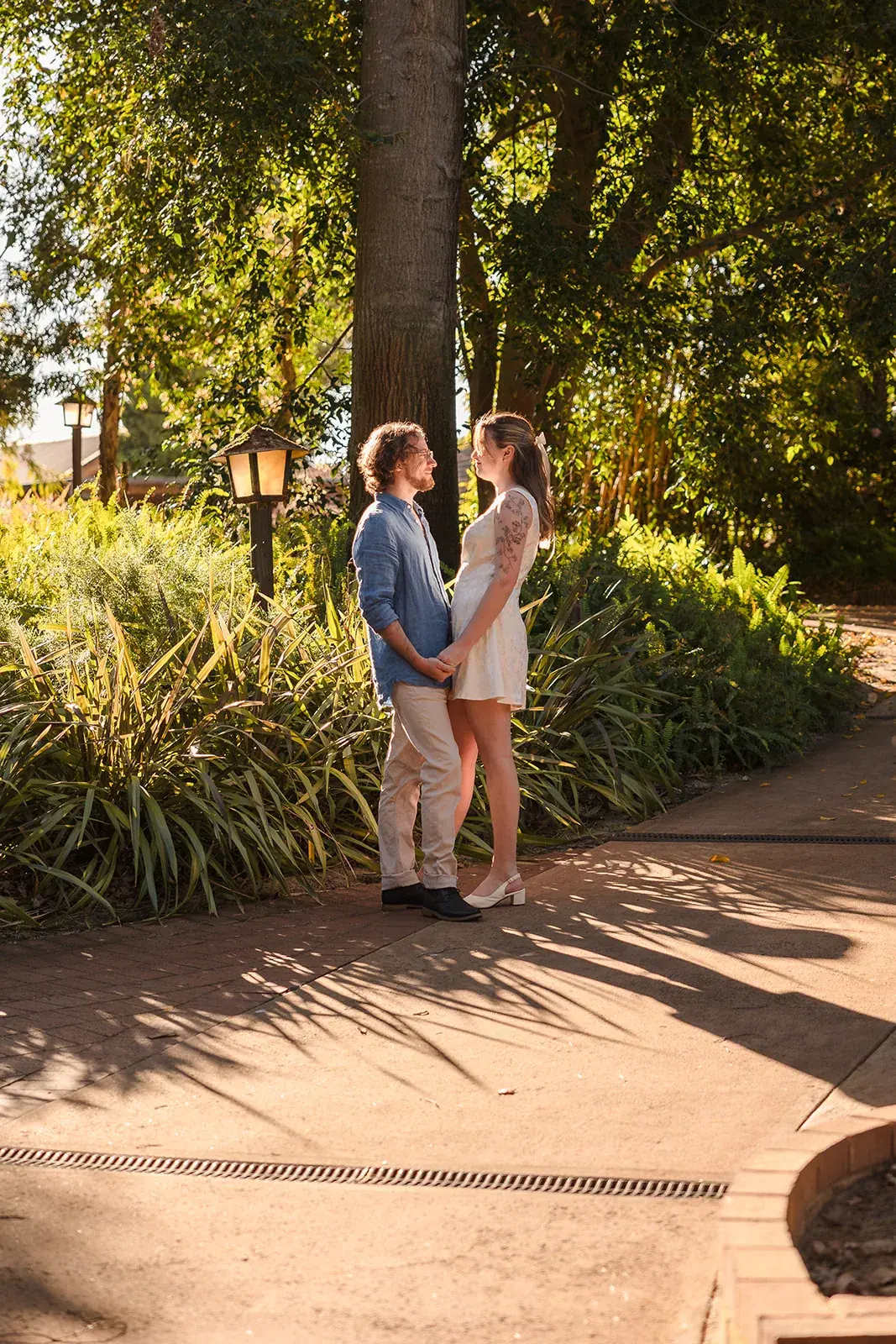 A couple on a tree-lined garden path at Wanneroo Botanic Gardens