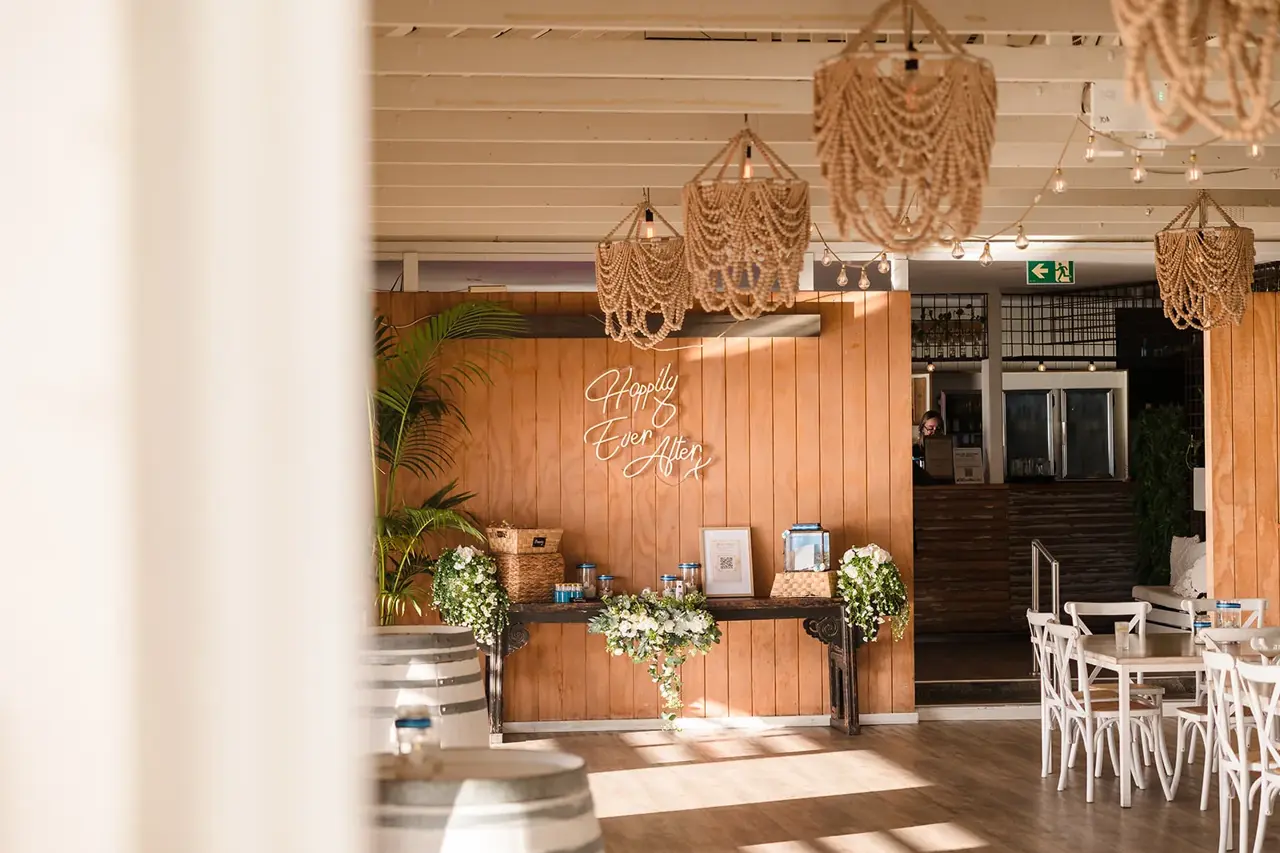 Rattan pendant lights and timber interior at a COAST Port Beach wedding