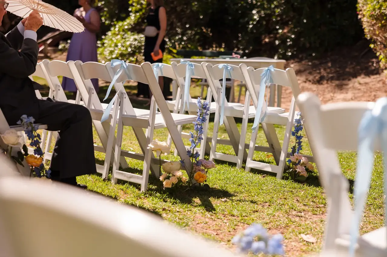 White ceremony chairs set up in the garden at Cottesloe Civic Centre