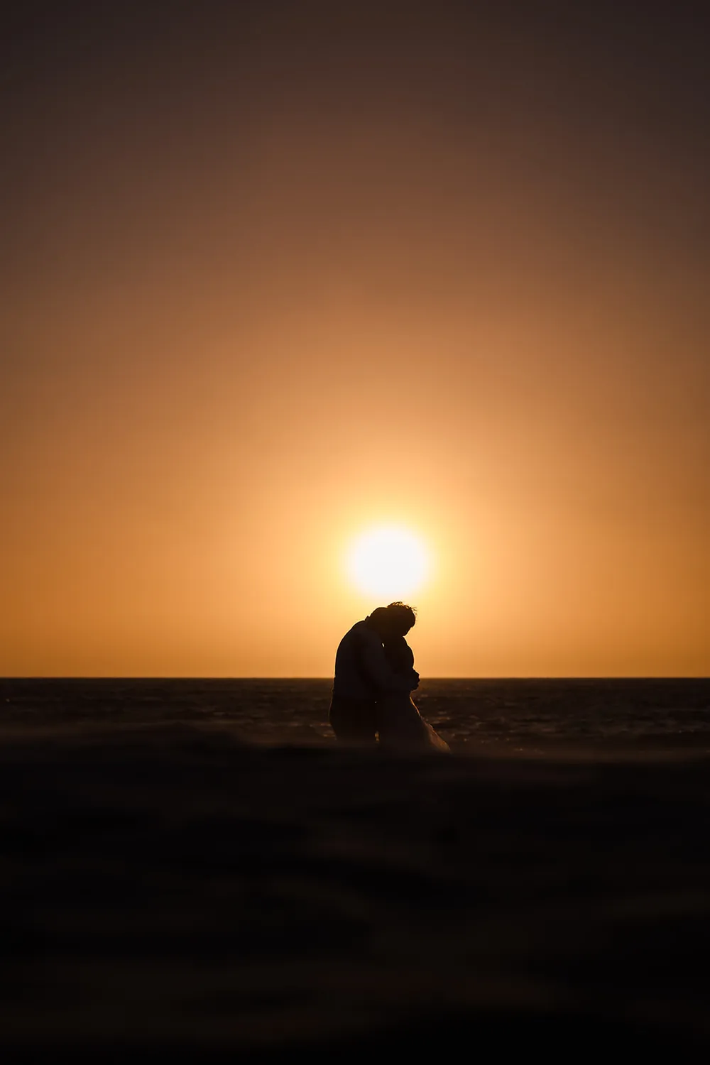 Jaana and Andy kissing at sunset on the beach at Port Beach, Perth