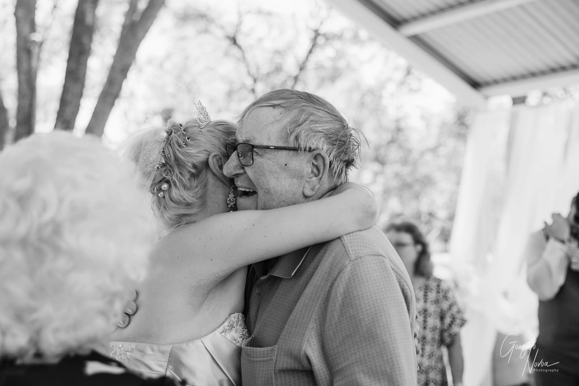 The bride embraces a guest tightly, a tender moment of love and appreciation on her wedding day.