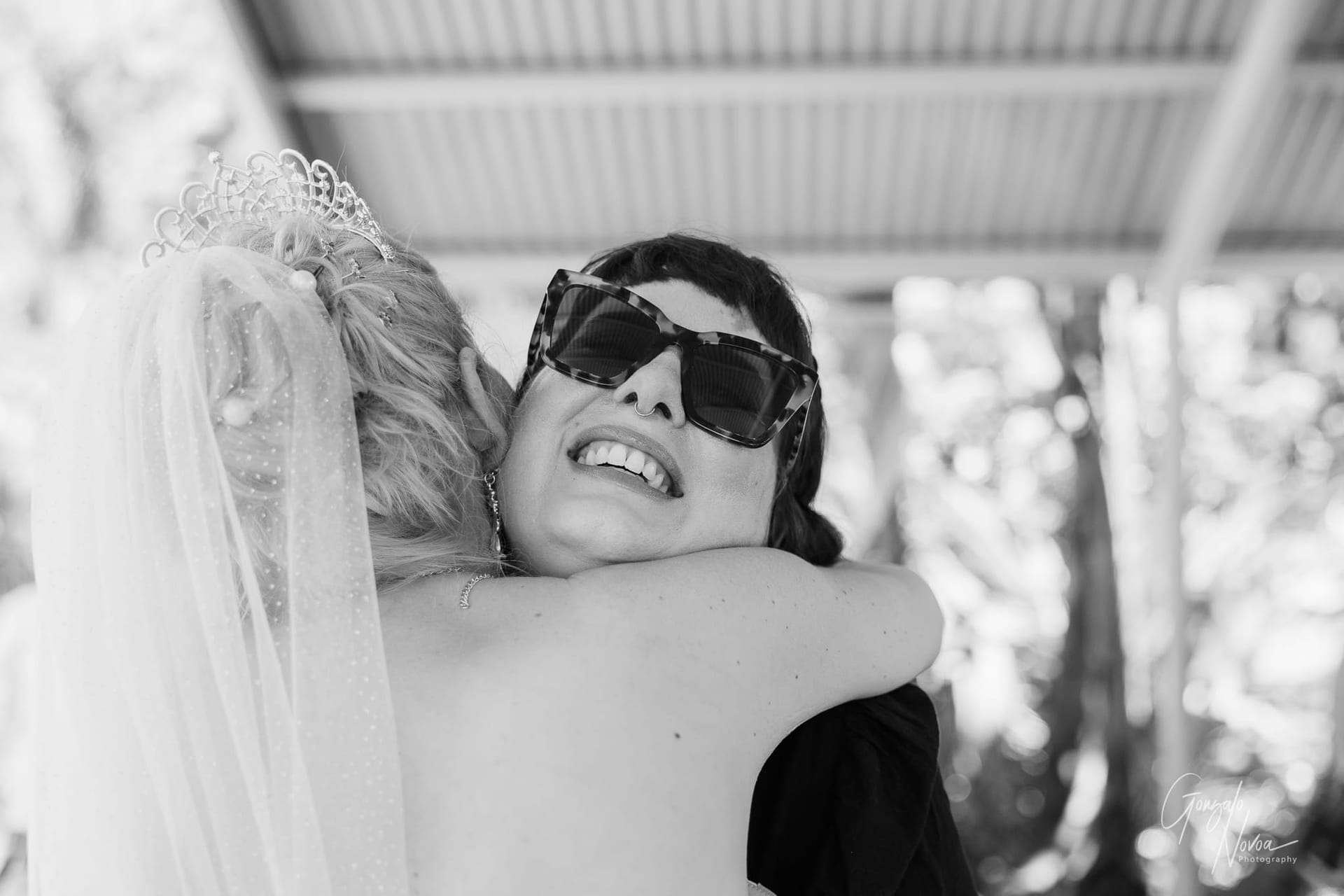 A bride shares a heartfelt hug with a wedding guest, their embrace filled with warmth and emotion.