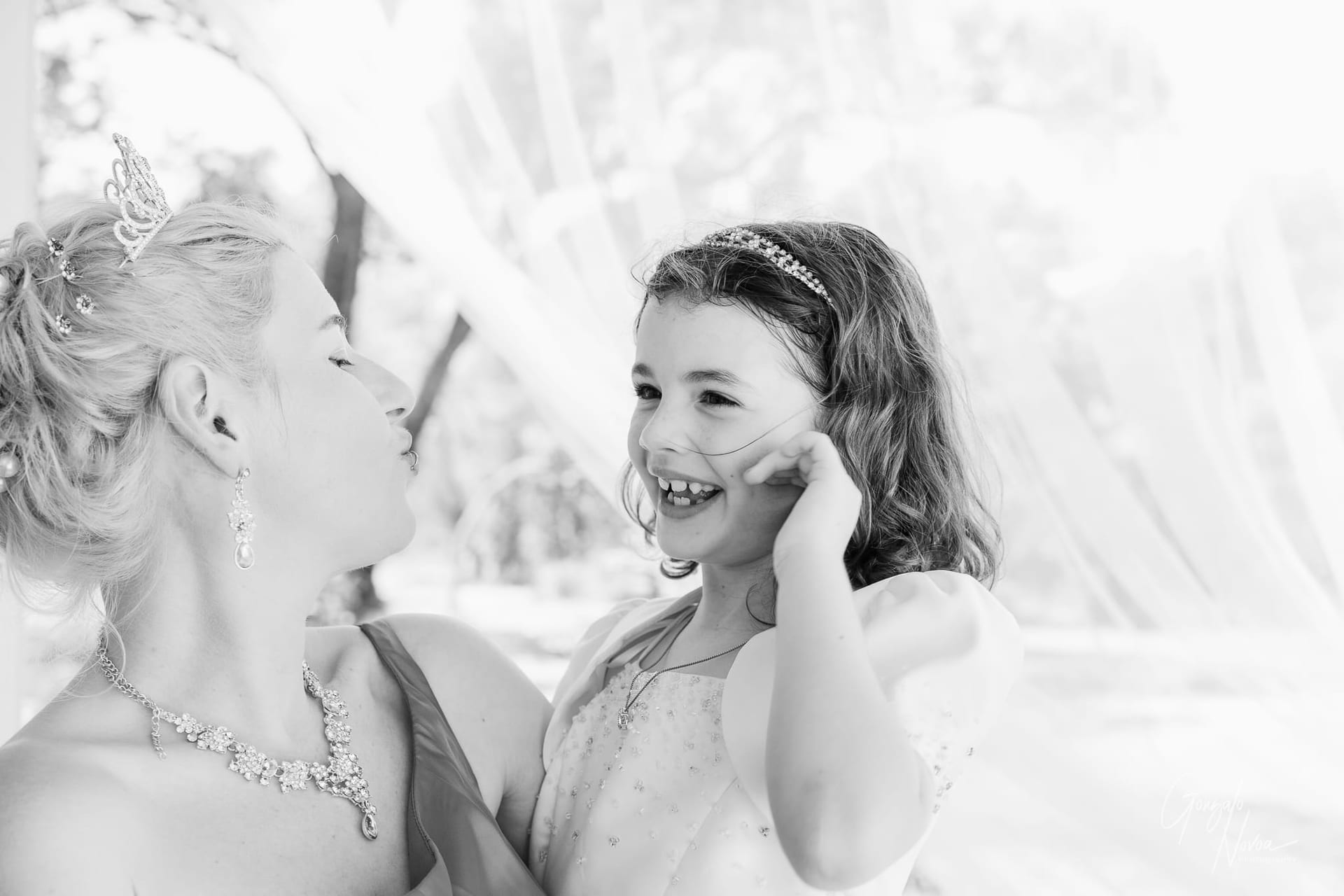 A close-up of a heartfelt hug between the bride and her daughter, surrounded by a beautiful outdoor setting.