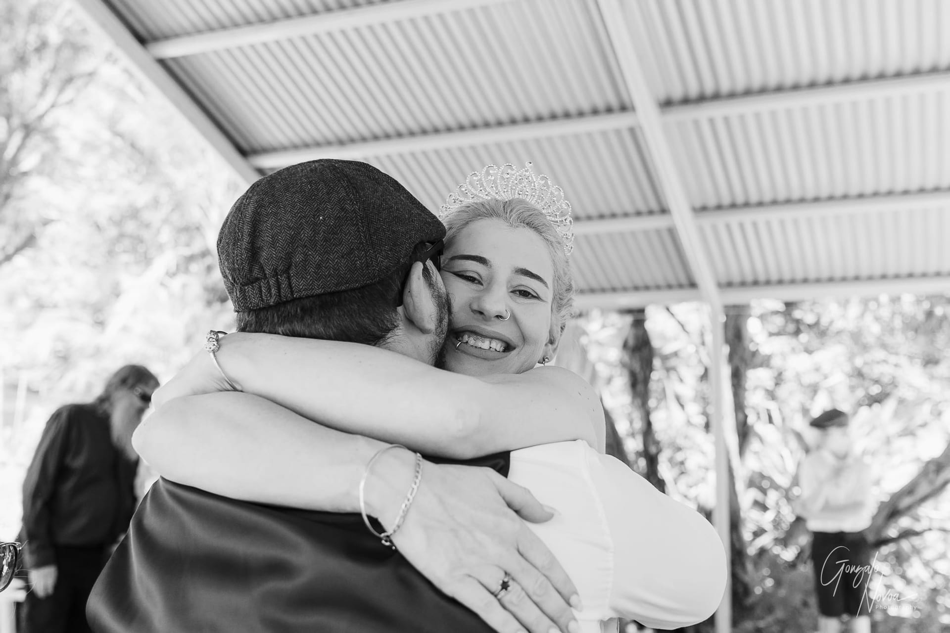 he bride holds onto a loved one during an emotional embrace, a moment of pure connection and joy.