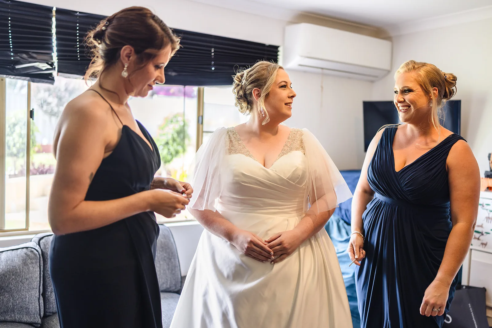 Jess getting ready in her wedding dress with her bridesmaids at home in Clarkson