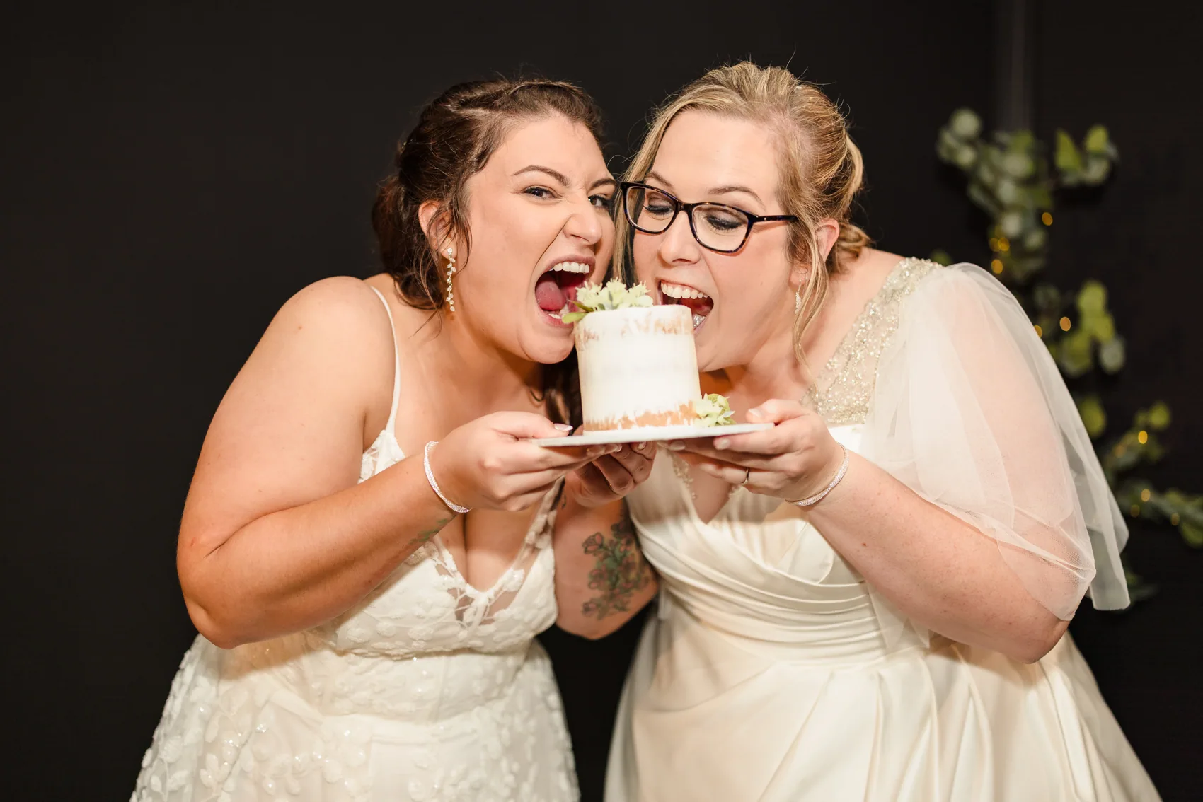 Kat and Jess sharing a bite of their wedding cake