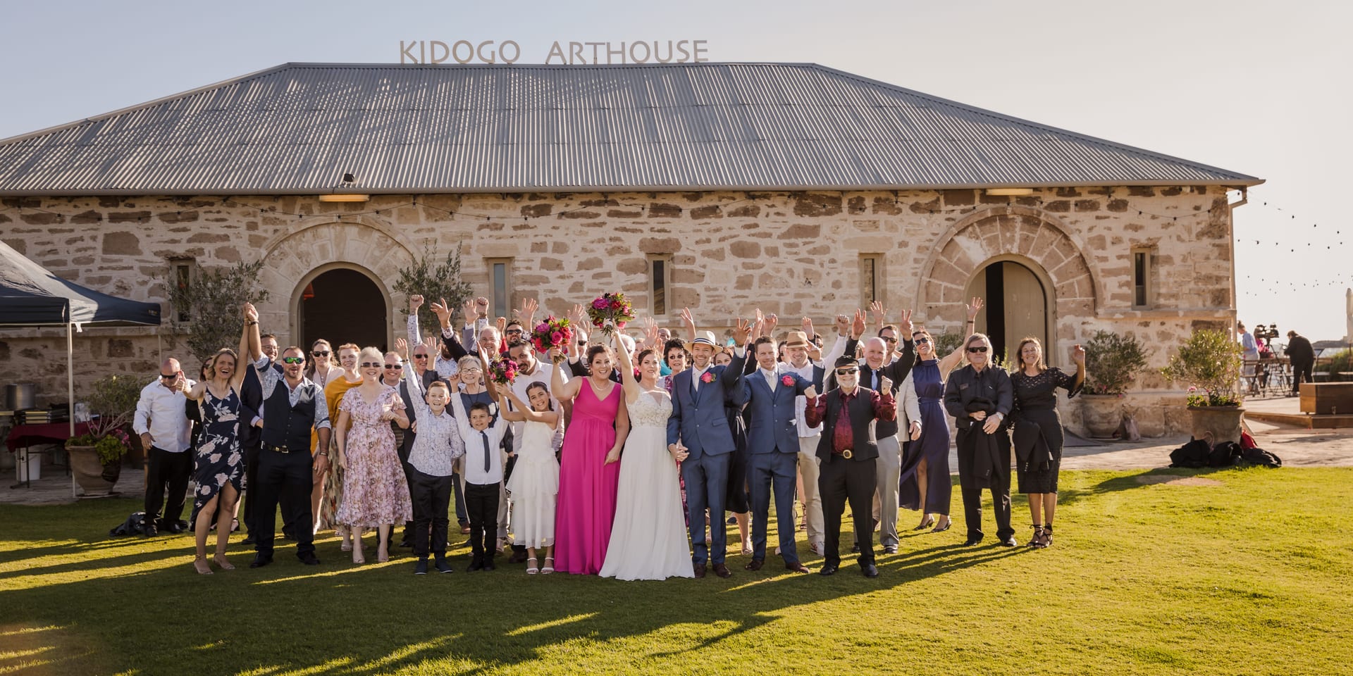 Wedding guests gathered for a group photo outside Kidogo Arthouse.