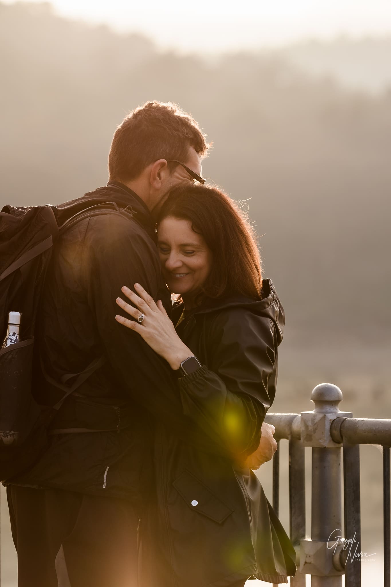 Gentle smiles, Maria and Fabio embracing each other with warm sunrise light behind them