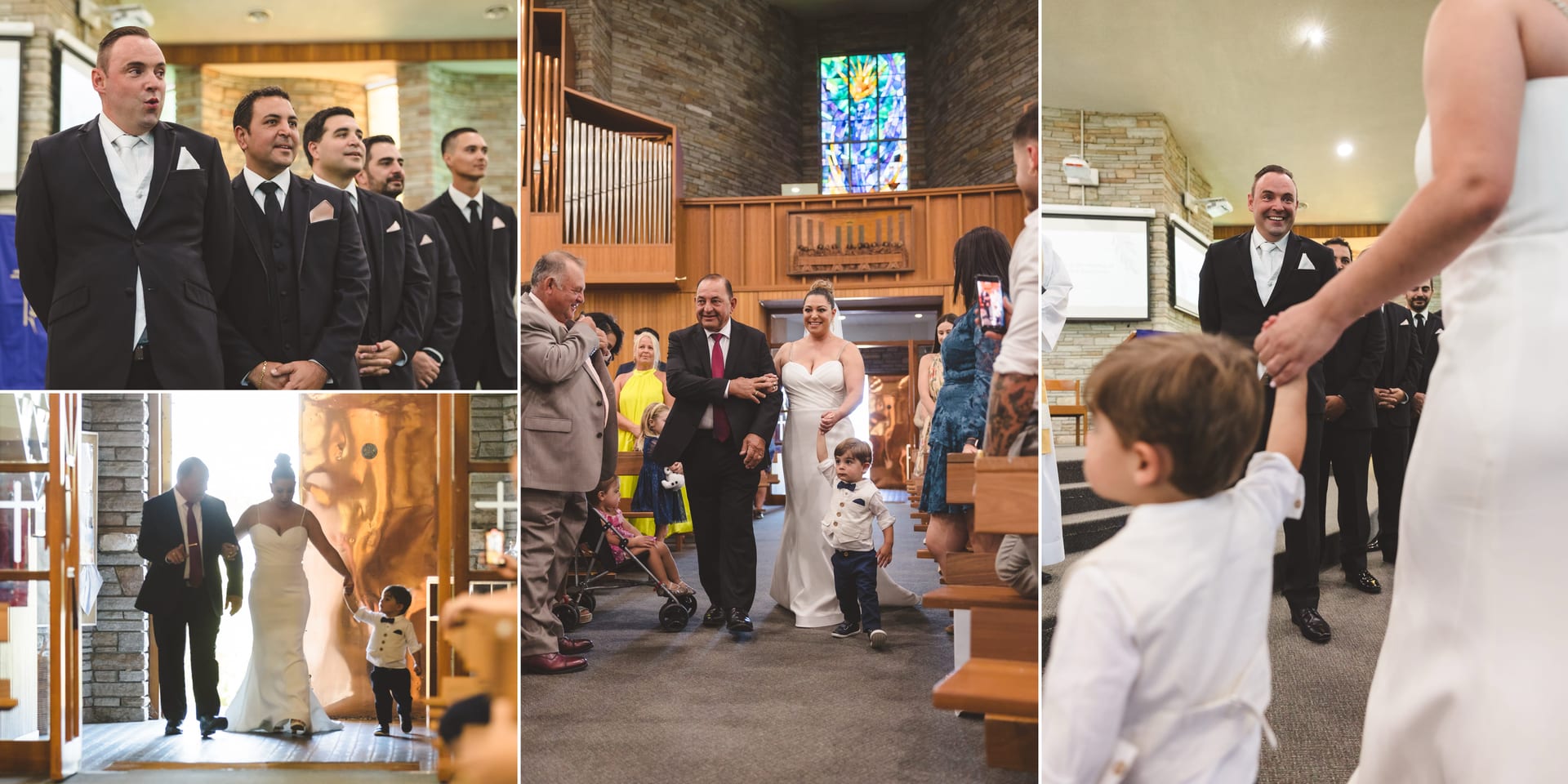 Groom and groomsmen await inside a stone-walled church. Bride in white walks down the aisle with a boy, holding hands, stained glass window behind.