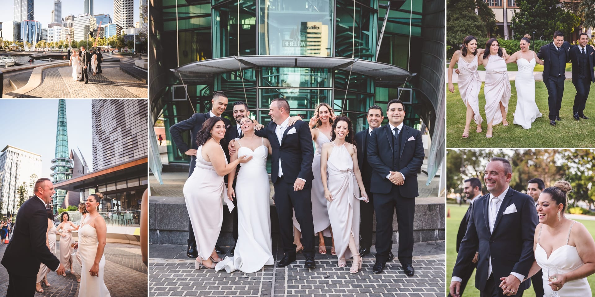 A joyful wedding party poses in formal attire outside modern glass buildings in a cityscape setting, with smiles and laughter.