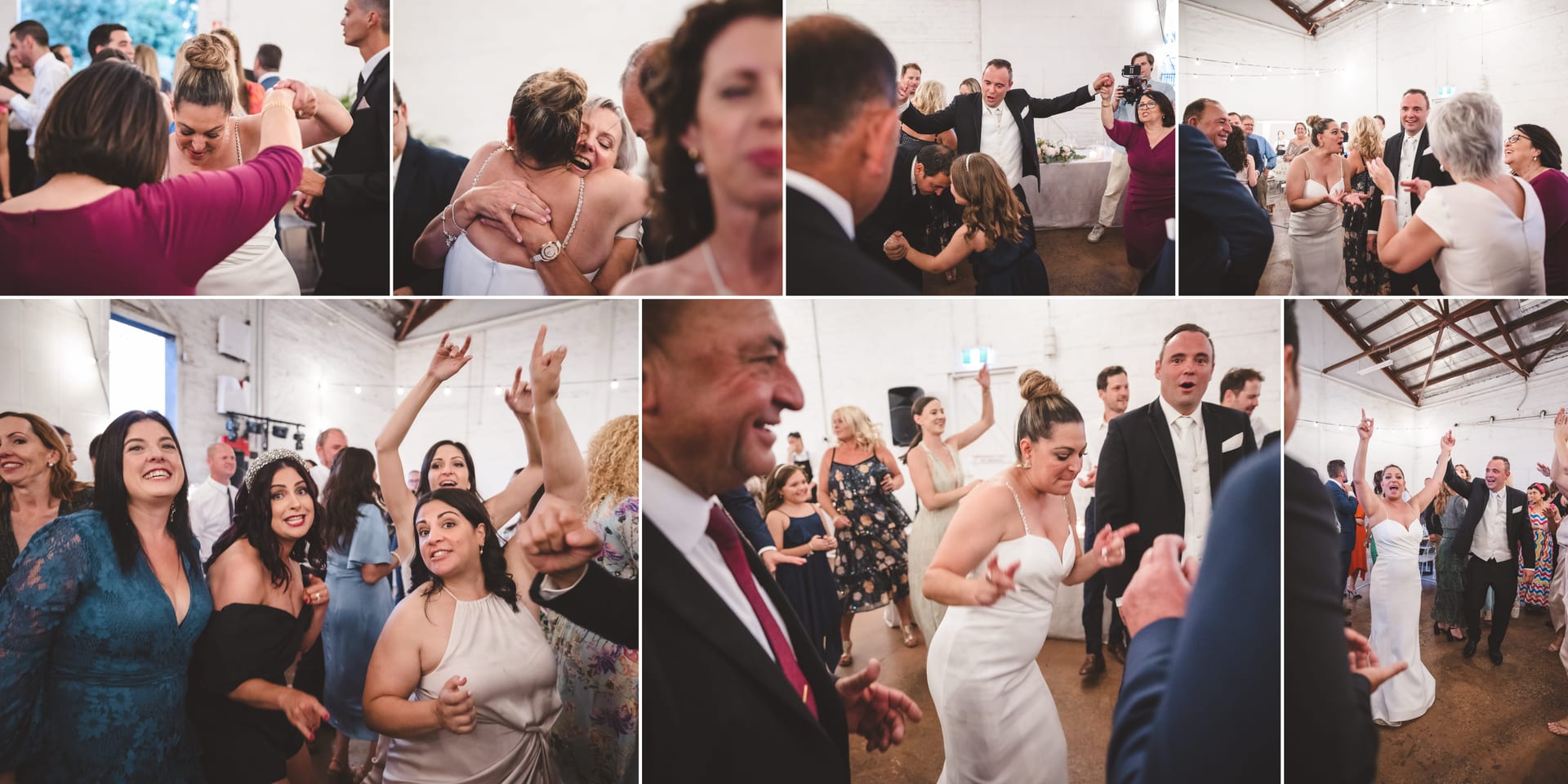 People dancing joyfully at a wedding reception in a rustic venue with string lights. Smiles, embraces, and celebratory gestures fill the scene.