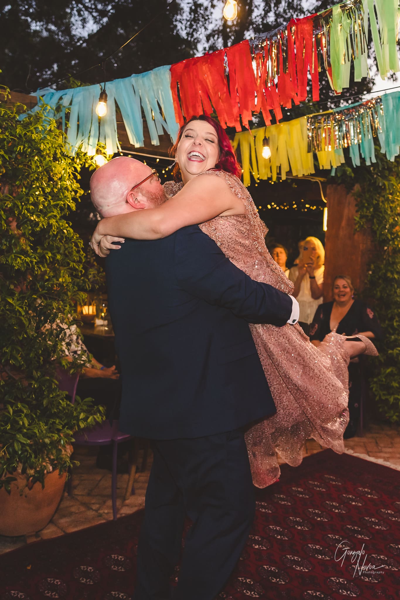 Bride and Groom dancing with the groom lifting the bride  up in the air!