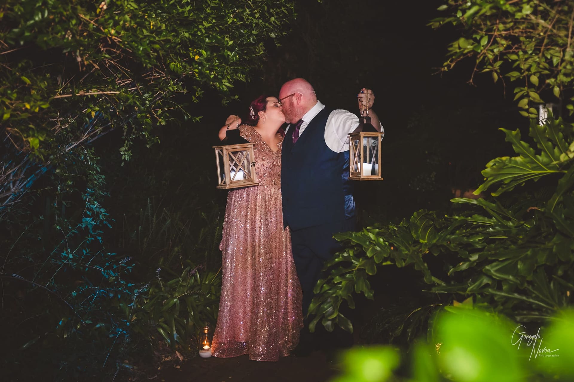 Bride and groom holding hand lanterns in the middle of the night