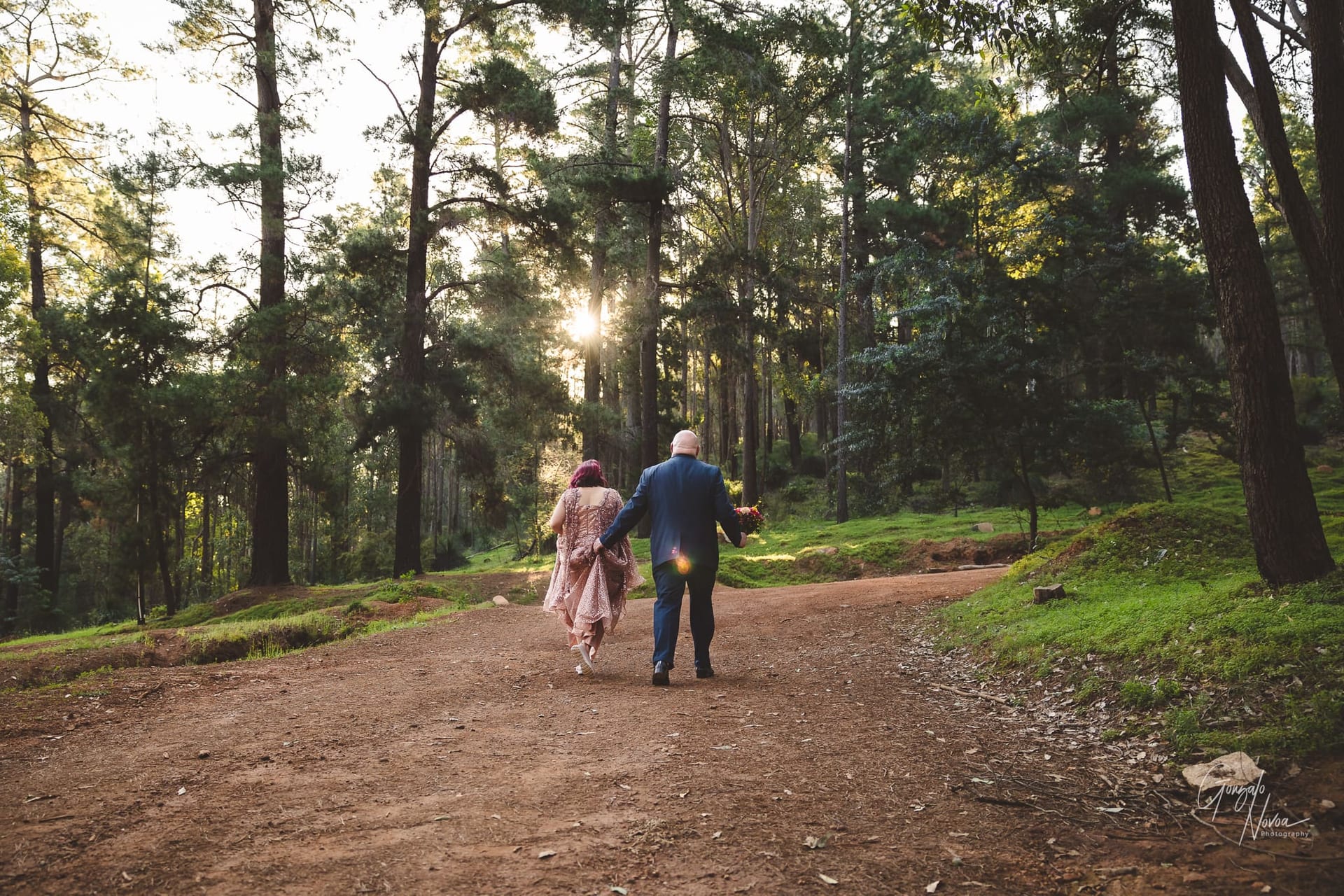Bride and Groom walking into the forest