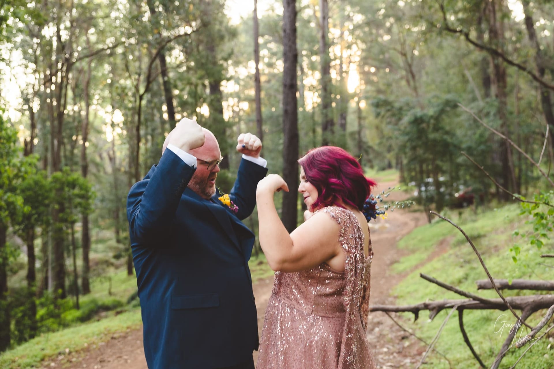 Flex them muscles! Bride and groom playfully flexing their biceps at each other