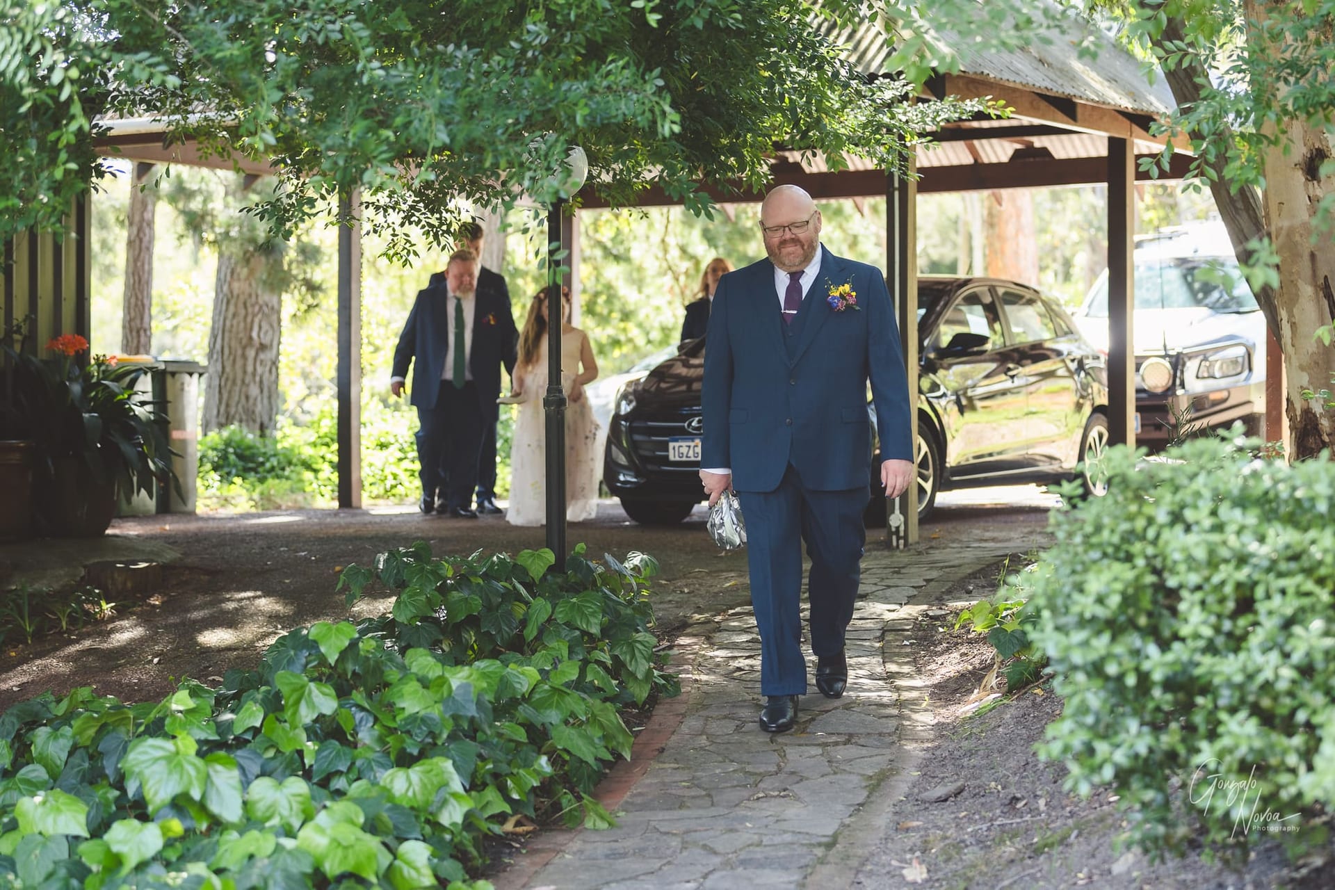 The groom in his suit confidently strolls along a path, exuding elegance and purpose.