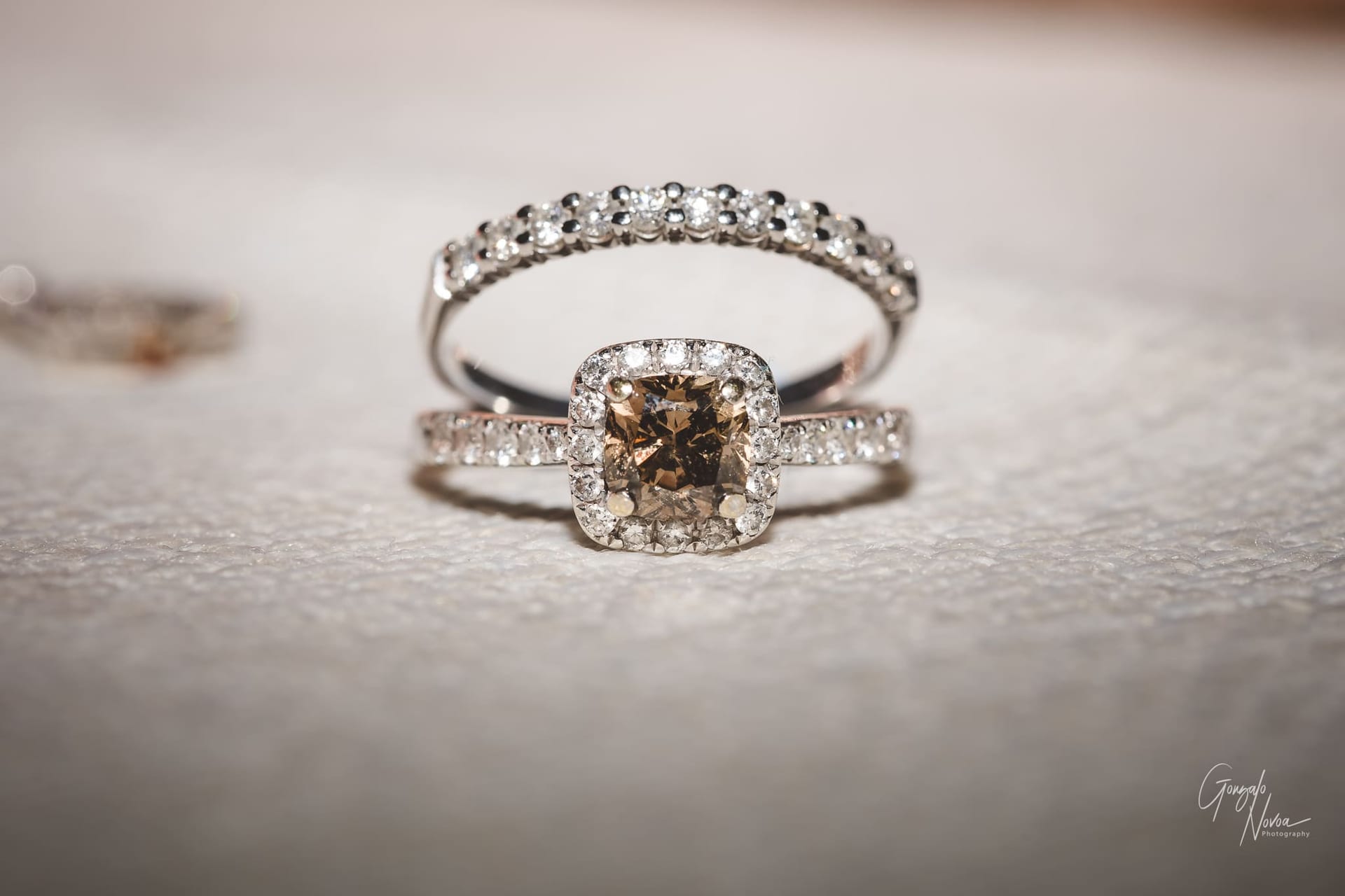 Two diamond rings, one with brown diamond, on a white background.